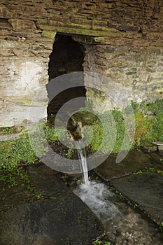 Rustic fountain of a mountain village photo