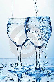 Pure water pouring into glasses
