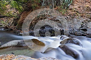 Pure water stream with smooth flow over rocky mountain terrain in the Kakopetria forest in Troodos, Cyprus