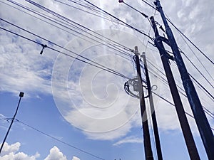 pure white clouds in a bright blue sky above a power pole