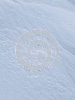 Pure white snow background texture. Winter background with snow embankments. Snow drifts after a blizzard, present. Details of the