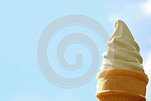 Pure White Vanilla Soft Serve Ice Cream Cone against Sunny Bright Blue Sky, with Free Space for Design