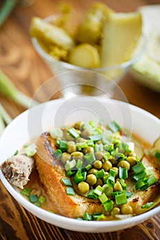 Puree soup with green peas, pickled cucumbers and croutons