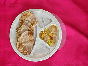 Puri and Potato Curry aalu sabji - an indian cuisine in round plate.