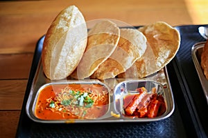 Puri Sabji or Poori Sabzi. Indian snack. Indian fried bread served with spicy vegetable curry and spicy pickles. Delicious looking