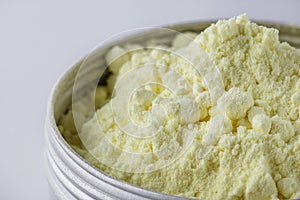 Purified sulfur powder on a white acrylic background