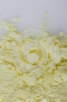 Purified sulfur powder on a white acrylic background