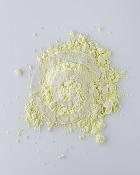 Purified sulfur powder on a white acrylic background