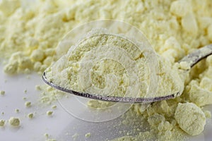 Purified sulfur powder on a white acrylic background