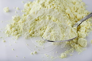 Purified sulfur powder on a white acrylic background