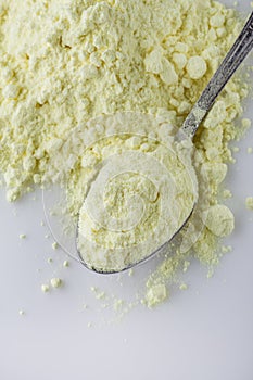 Purified sulfur powder on a white acrylic background