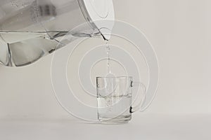 Purified water in a jug with a filter and a transparent glass