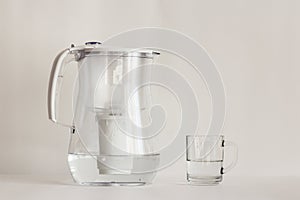 Purified water in a jug with a filter and a transparent glass photo