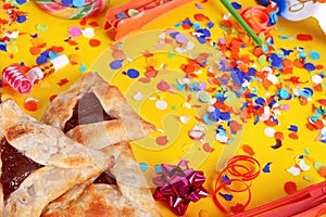 Purim background with carnival mask, party costume and hamantaschen cookies.