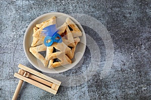 Purim celebration concept with hamantashen cookies, Purim mask and toy noisemaker on grey background