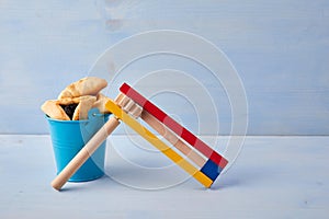 Purim celebration concept with hamantashen cookies, Purim toy noisemaker on blue background