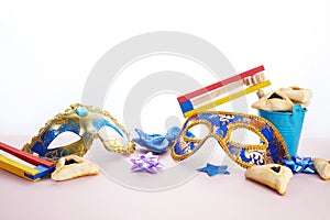 Purim celebration concept. Hamantashen or haman ears, noisemaker and mask on white background