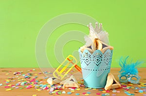 Purim celebration concept jewish carnival holiday over green wooden background