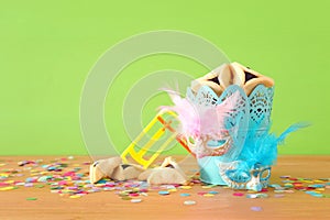 Purim celebration concept jewish carnival holiday over green wooden background