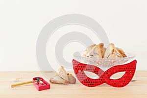 Purim celebration concept jewish carnival holiday over wooden table.