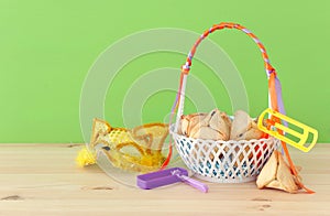 Purim celebration concept & x28;jewish carnival holiday& x29;. Traditional hamantaschen cookies in the basket over wooden table.
