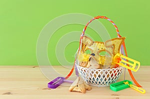 Purim celebration concept & x28;jewish carnival holiday& x29;. Traditional hamantaschen cookies in the basket over wooden table.