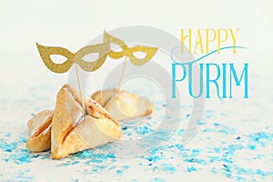 Purim celebration concept & x28;jewish carnival holiday& x29;. Traditional hamantaschen cookies with cute gold masks