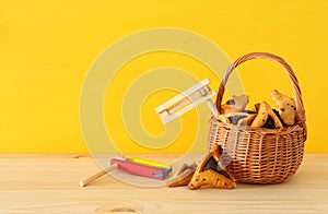 Purim celebration concept & x28;jewish carnival holiday& x29;. Traditional hamantaschen cookies and noisemaker over wooden table.