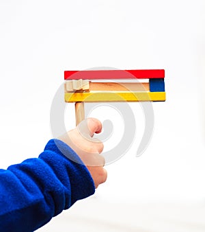 Purim. A child's hand holding Colorful wooden noisemaker