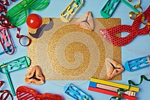 Purim golden glitter background with carnival mask, party costume and hamantaschen cookies.