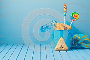 Purim traditional gifts with hamantaschen cookies, noisemaker and carnival mask photo