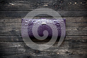 Purlple leather wallet on wooden background top view