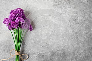 Purple alium flowers bouquet on gray concrete background with copy space. top view. flat lay