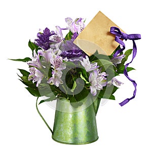 Purple alstroemeria and ornamental cale with green leaves in a green metal jar with empty paper card and ribbon bow isolated