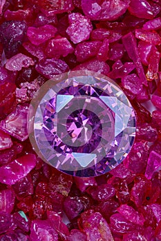 purple amethyst placed on a pile of raw granit gemstones