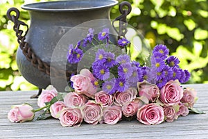 Purple aster and pink roses with a antique vase