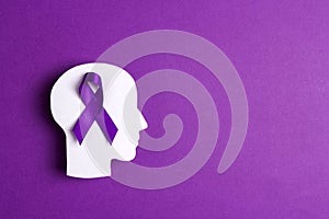 Purple awareness ribbon and head silhouette on a purple background