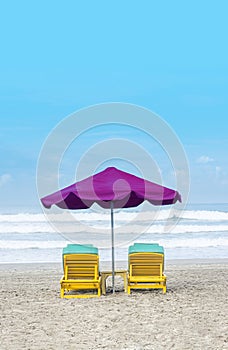 Purple Beach Umbrella With Yellow Lazy Wooden Chair on The Bali Beach During Summer Vacation