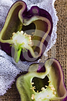 Purple bell pepper, Sweet Pepper Tequila, Capsicum annum, cut pieces, against a textile background with copy space