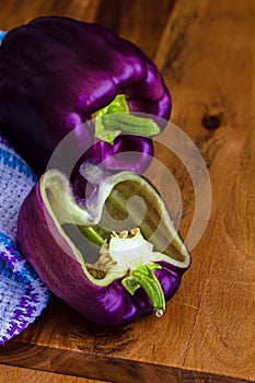 Purple bell peppers, Sweet Pepper Tequila, Capsicum annum, against a wood board background with copy space