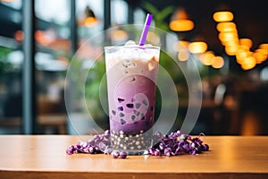 Purple berries milk shake with tapioca sweet balls, asian trendy iced drink bubble tea on wooden table in cafe.