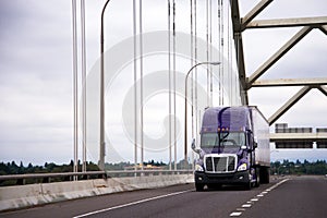 Purple big rig semi truck with dry van trailer for long haul car