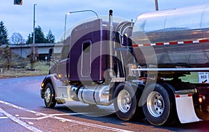 Purple big rig semi truck transporting fuel in tank semi trailer