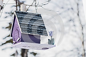 Purple bird house on a lens blured background
