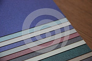 Purple blue grey teal mint background texture of colored paper on wooden table