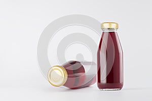 Purple blueberry juices in glass bottles with gold empty cap for label mock up on white background with copy space, template.