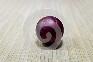 Purple bowling ball on the track in the bowling center