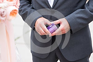 Purple box with an engagement ring in a man`s hands. Marriage proposal. Love.