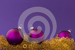 Purple christmas balls on gold glitter