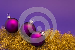 Purple christmas balls on gold glitter
